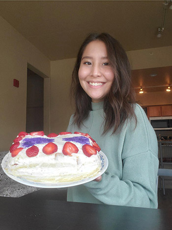 Azel Murzabekova, a Physics PhD student in Fahad Mahmood’s lab shows off the Intercalcated cake she created for the Bake-Your-Research Contest. (Image courtesy of Azel Murzabekova.)